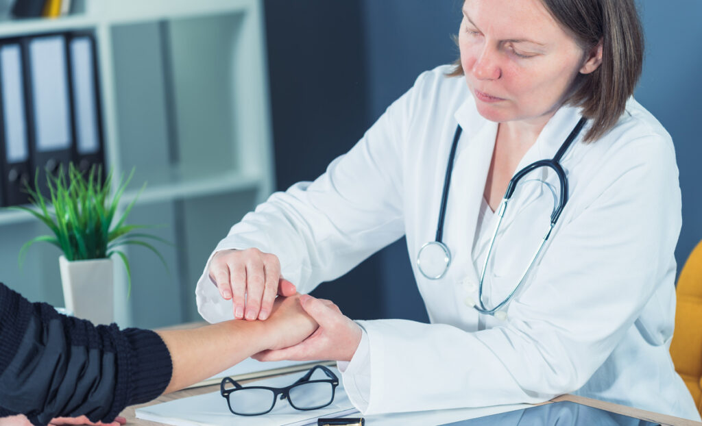 Female patient at orthopedic doctor medical exam for wrist injur